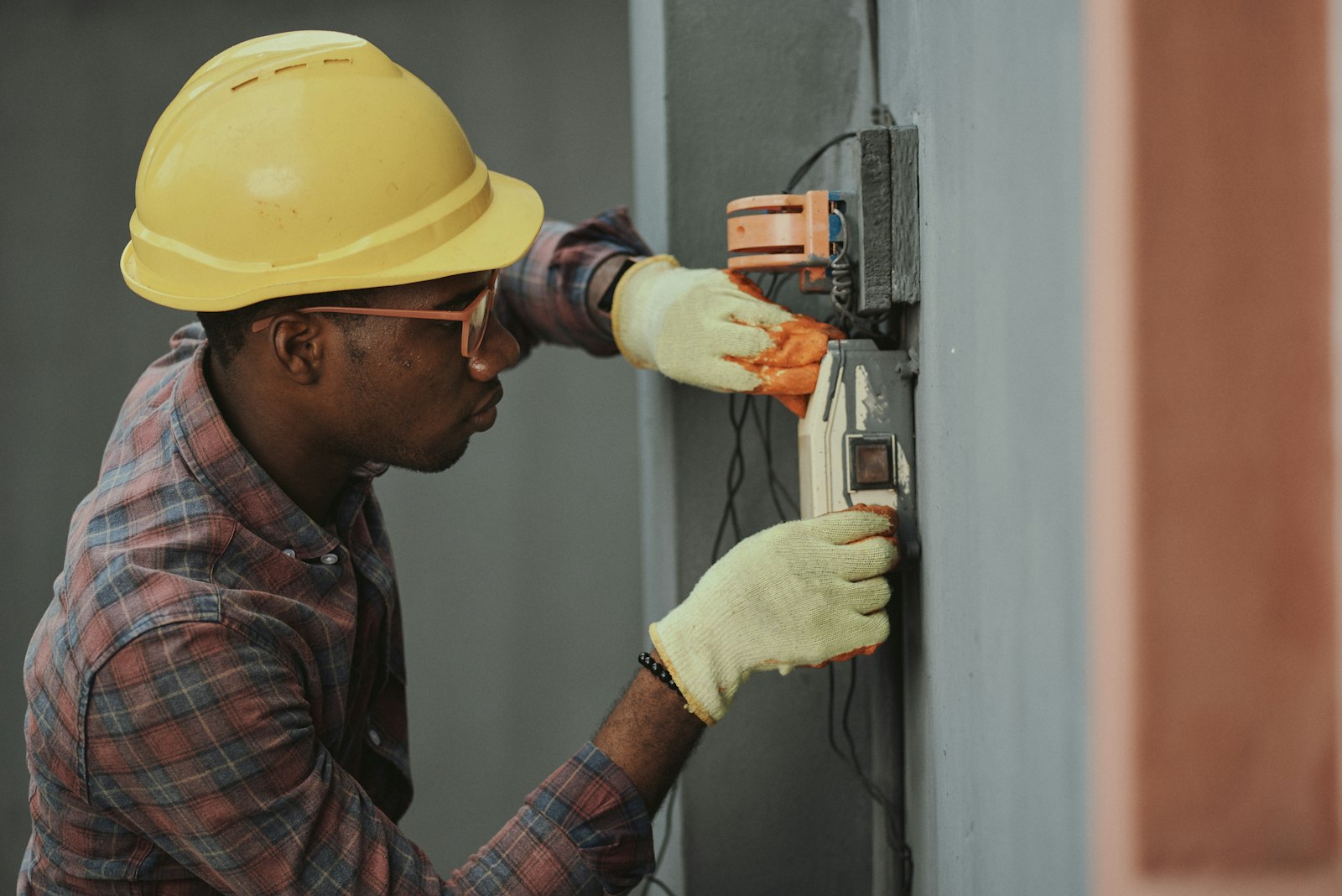 Builder fixing services to a wall during the first-fix stage of a garage conversion