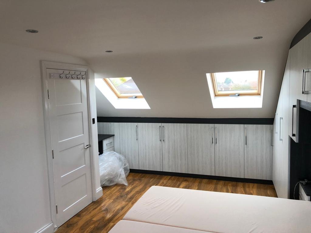 Loft bedroom with two Velux roof windows and built-in eaves storage