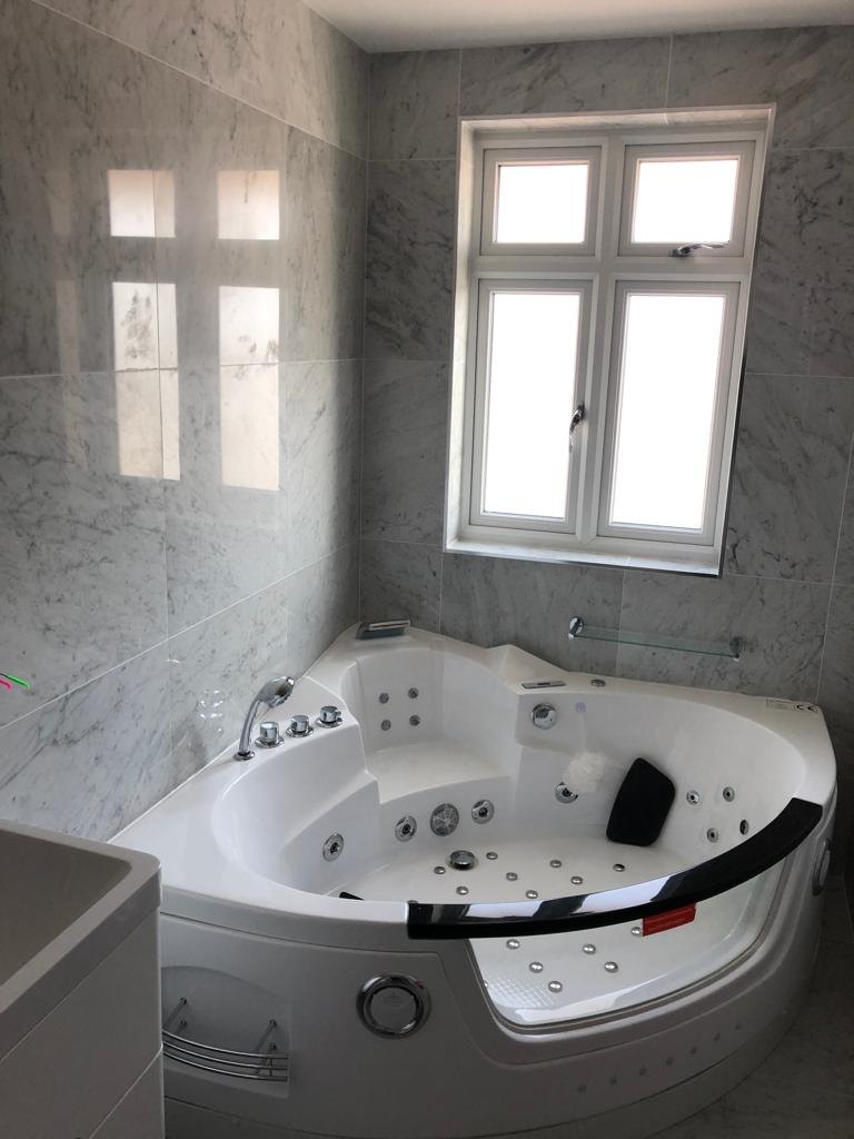 Corner whirlpool bath in a loft conversion en-suite bathroom