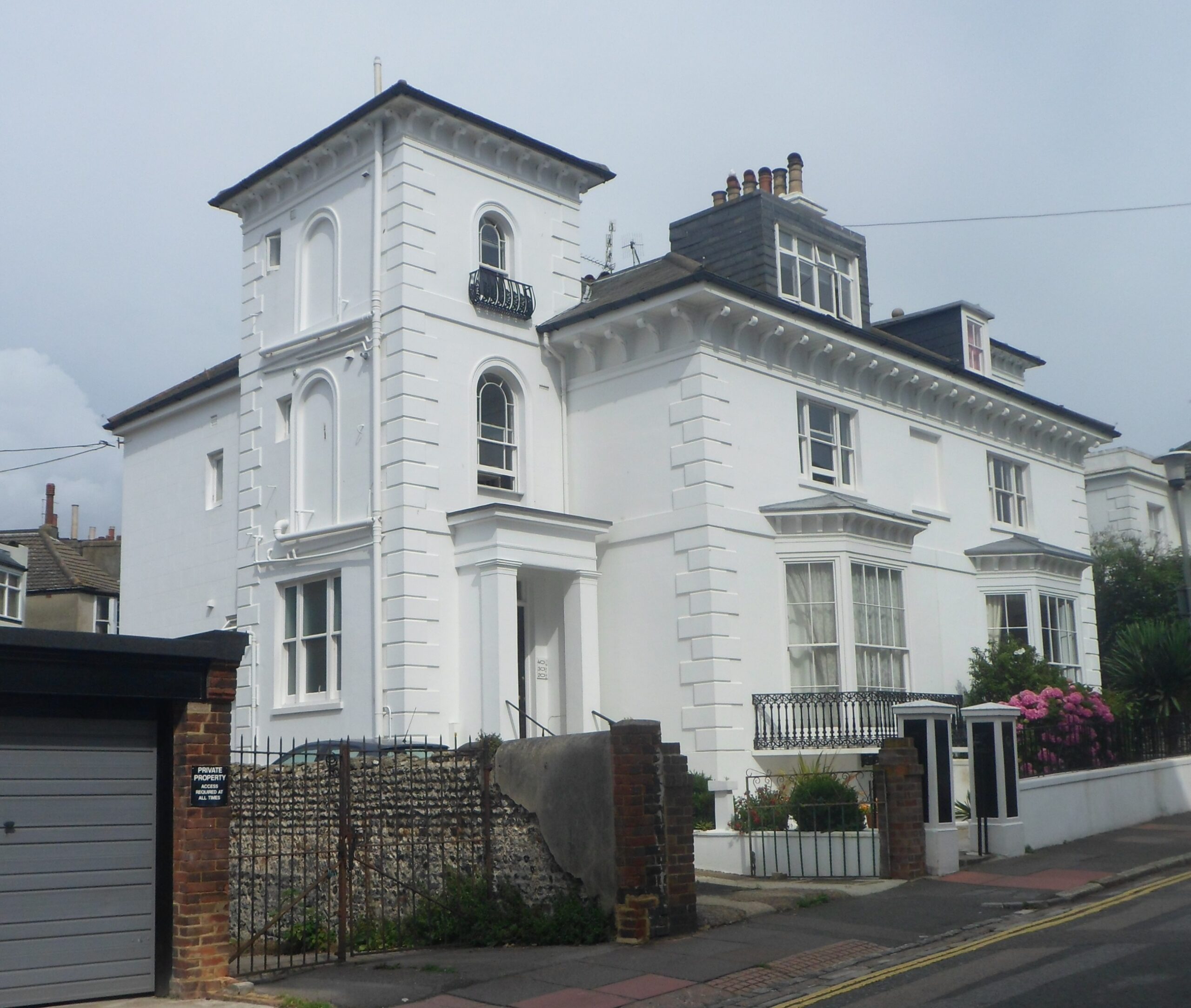 Painted white render terraced house with sash windows and railings